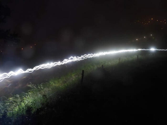 Les coureurs de l'ultra trail traversent les champs d'Aurillac dans la nuit, éclairé par leur frontale